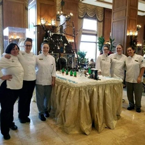 Aspen Galley and her coworkers pose for a photo in front of their artistic food creation