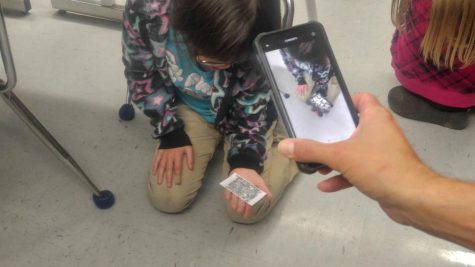 Mr. Wood using his phone to help a student see the space probe.