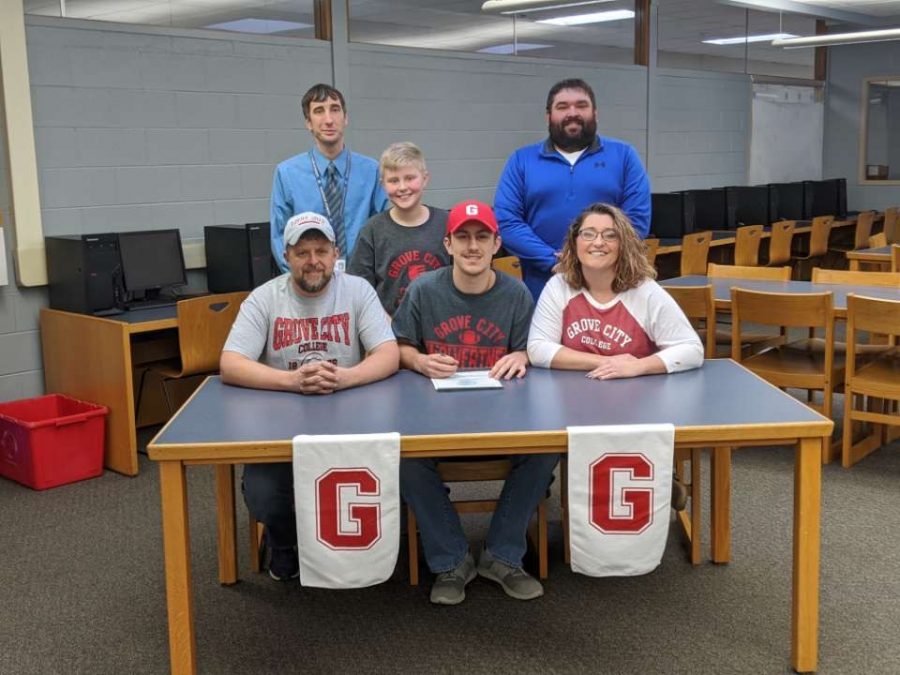 Ayden Gutierrez, surrounded by his family, Coach Hubler, and Mr. Williamson as he signs his letter of intent for Grove City College.