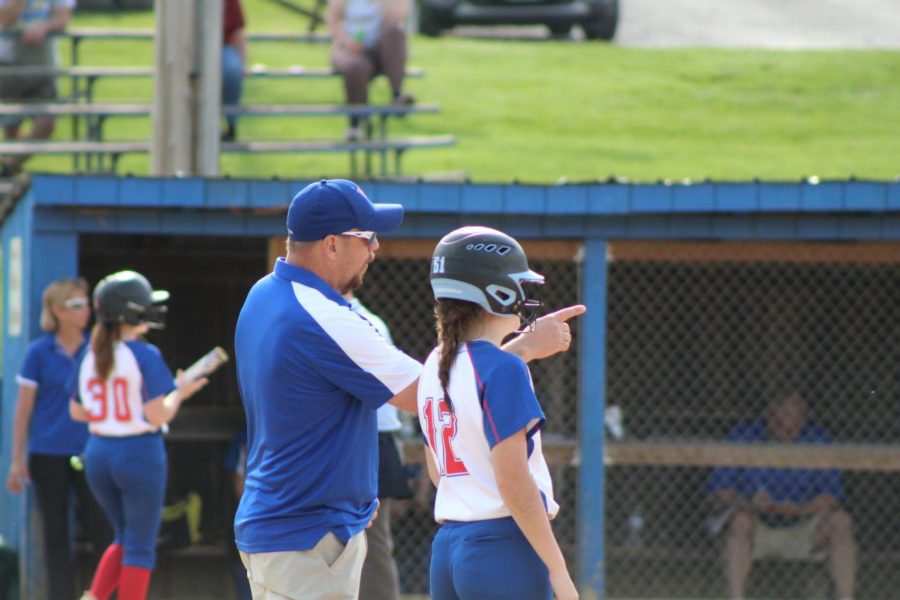 Hannah Betts stands with Coach Moore at first base after her hit.