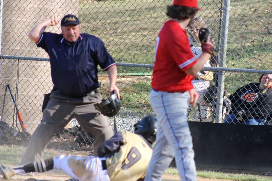 Owen Graham shows the ball to the umpire as he tagged out a runner trying to steal home