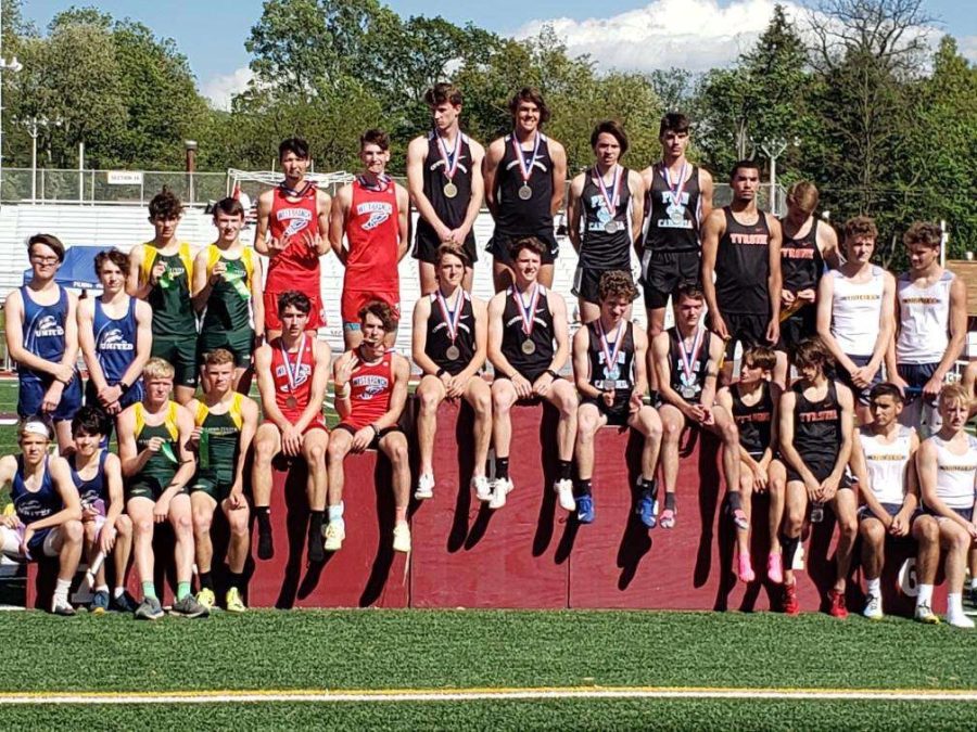 The boys 4 x 800 meter relay stands on the District 6 AA Championship podium after placing 3rd and securing their spot to the state championship.