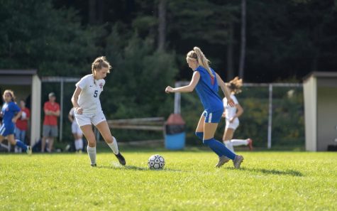 Jenna dribbles the ball toward the opposing team.