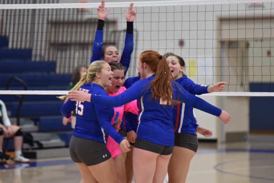 The Lady Warrior Volleyball team celebrates after winning a point.
