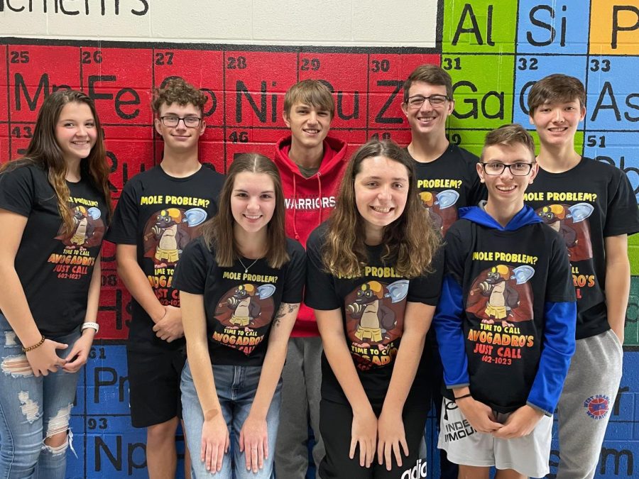 Chemistry II students pose in front of the Periodic Table in their matching Mole Day t-shirts.