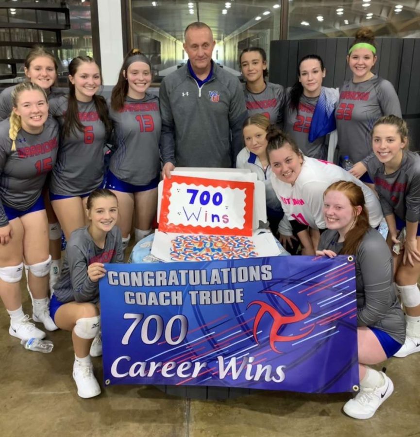 The Lady Warriors celebrate with head coach Terry Trude after collecting his 700th career win.