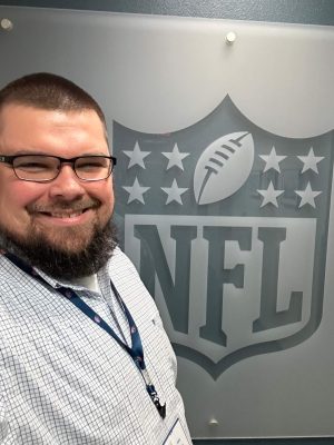 Andy poses for a photo with the NFL logo at his State College office.
