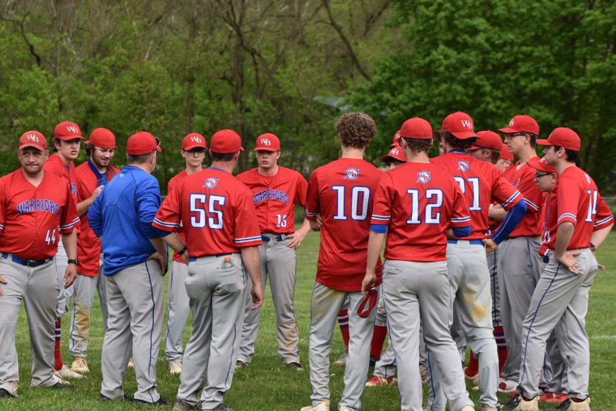 The baseball team gathers together after a win during the 2022 baseball season.