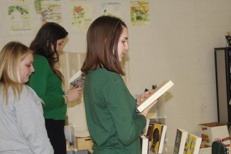 Book club members Kaitlyn McGonigal, Katrina Cowder, and Montana Williams check out book options at the group’s first meeting.