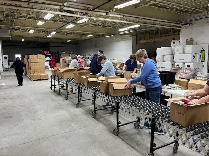 Volunteers of the Anti-Hunger Program assemble food packages for the box program.