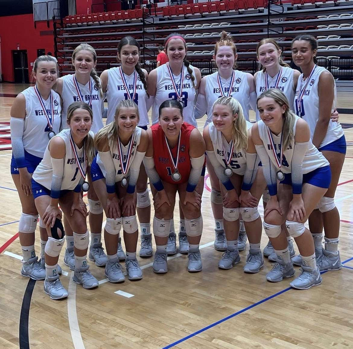 The Lady Warrior Volleyball team poses with their silver medals. 