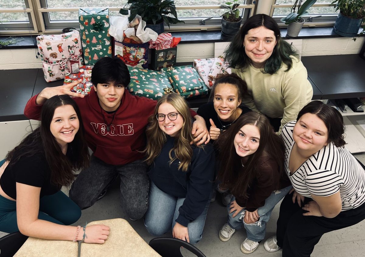 Mrs. Petersons sociology class gathers in front of the presents they wrapped for the YMCA Christmas Program. 