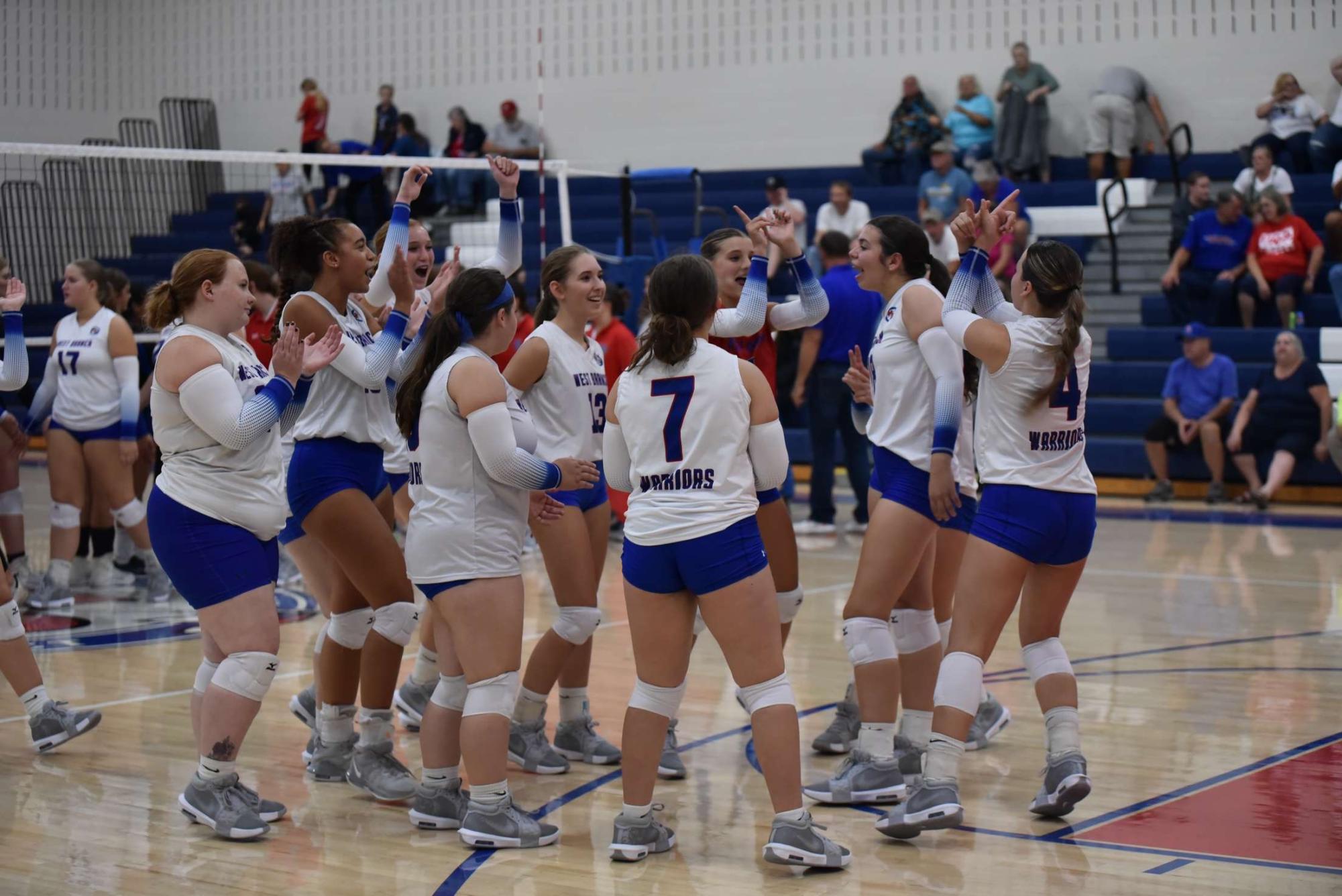 The Warriors celebrate their three-set win against Claysburg-Kimmel in their home opener. 