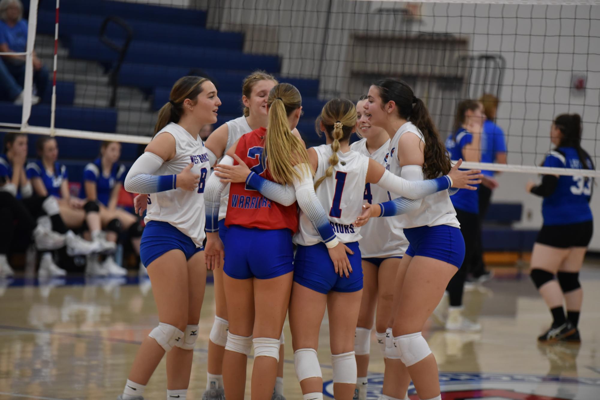 The Lady Warriors celebrate as a team on their home court.