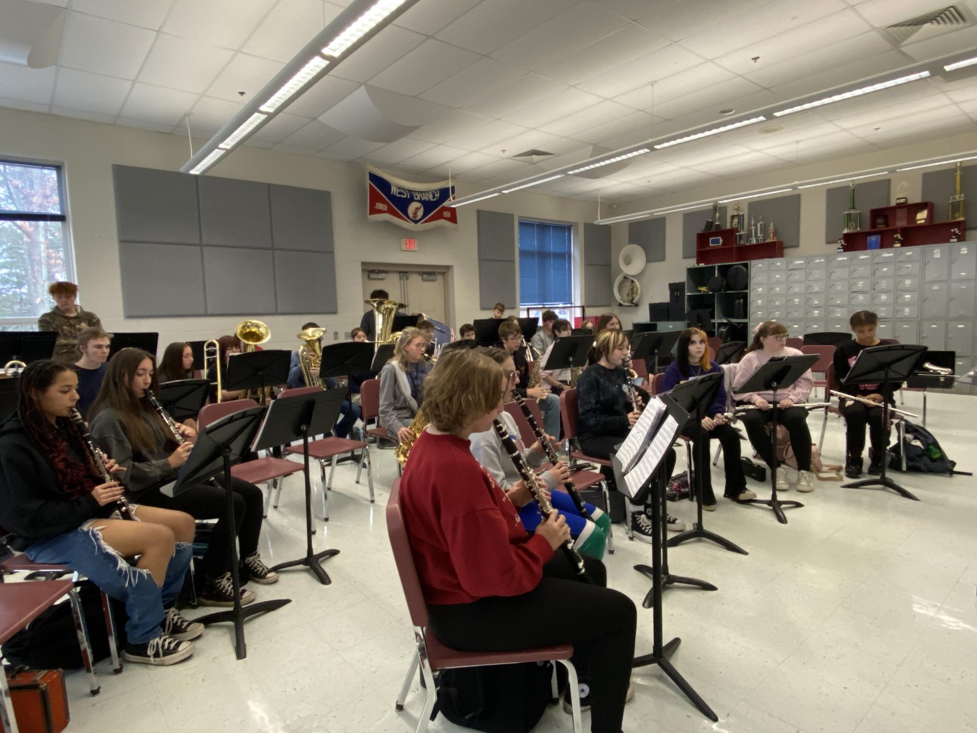 The high school concert band practices their music during rehearsal.
