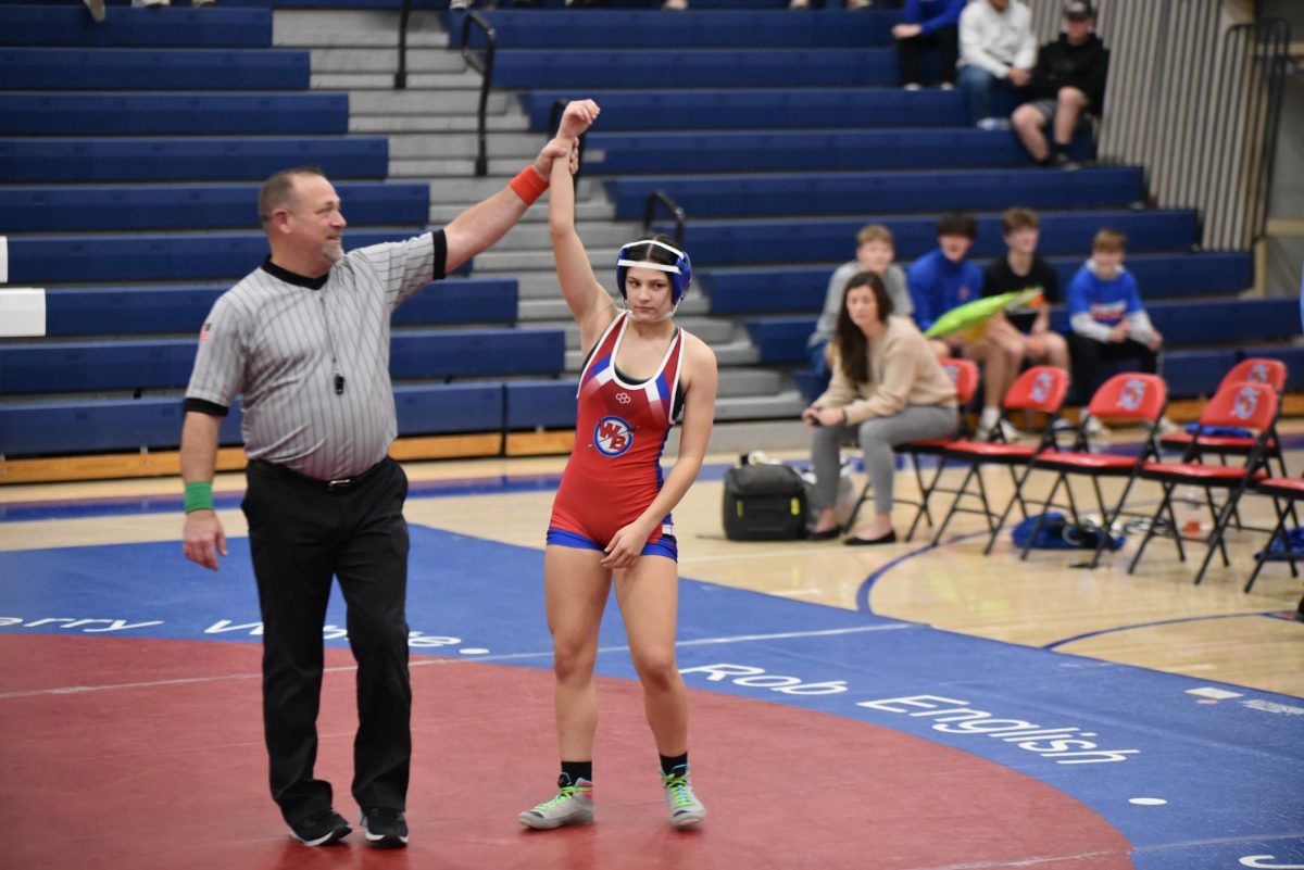 Natalie Yingling wins her match as the referee raises her hand in victory.