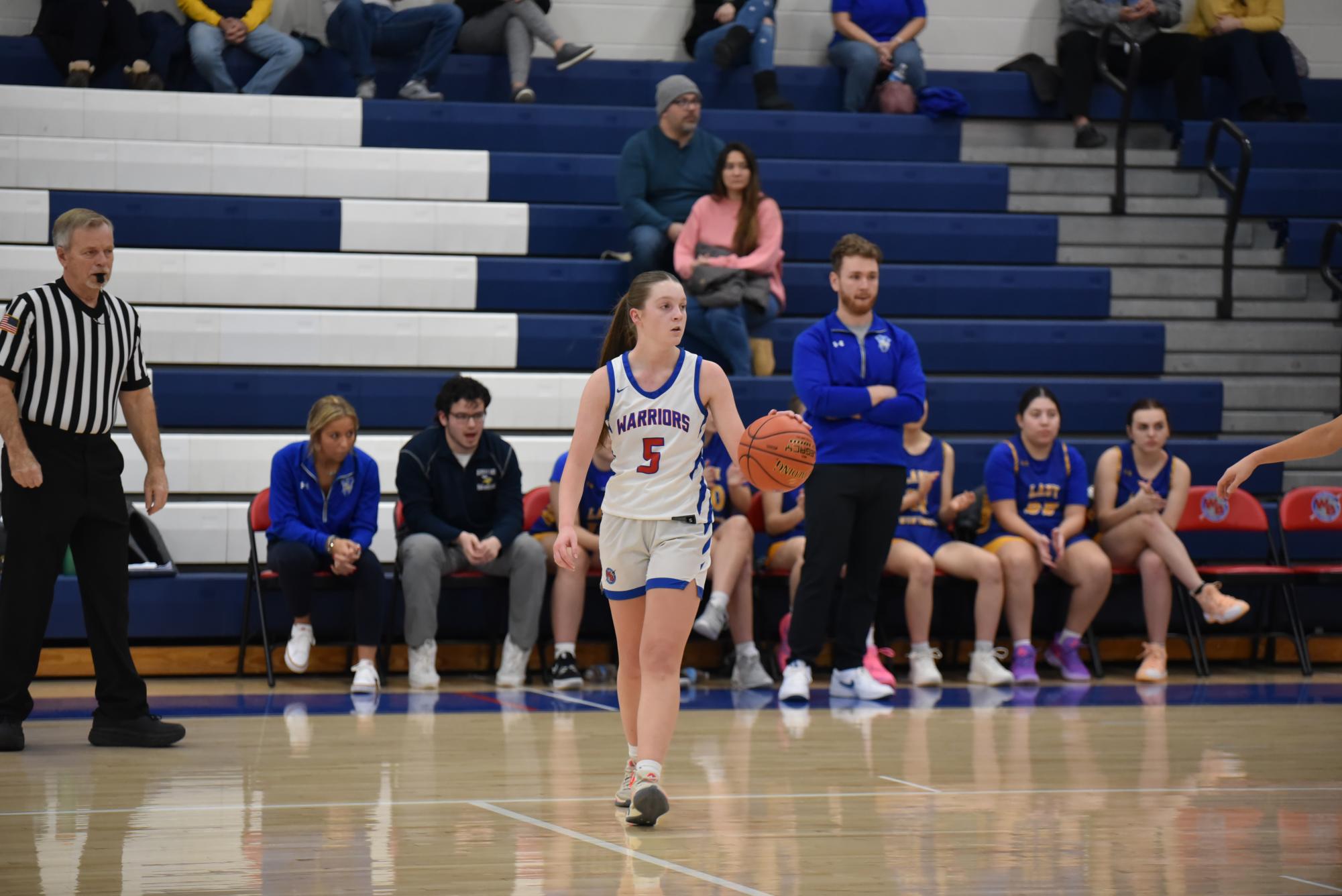 Sarah dribbles at the top of the key for a play.
