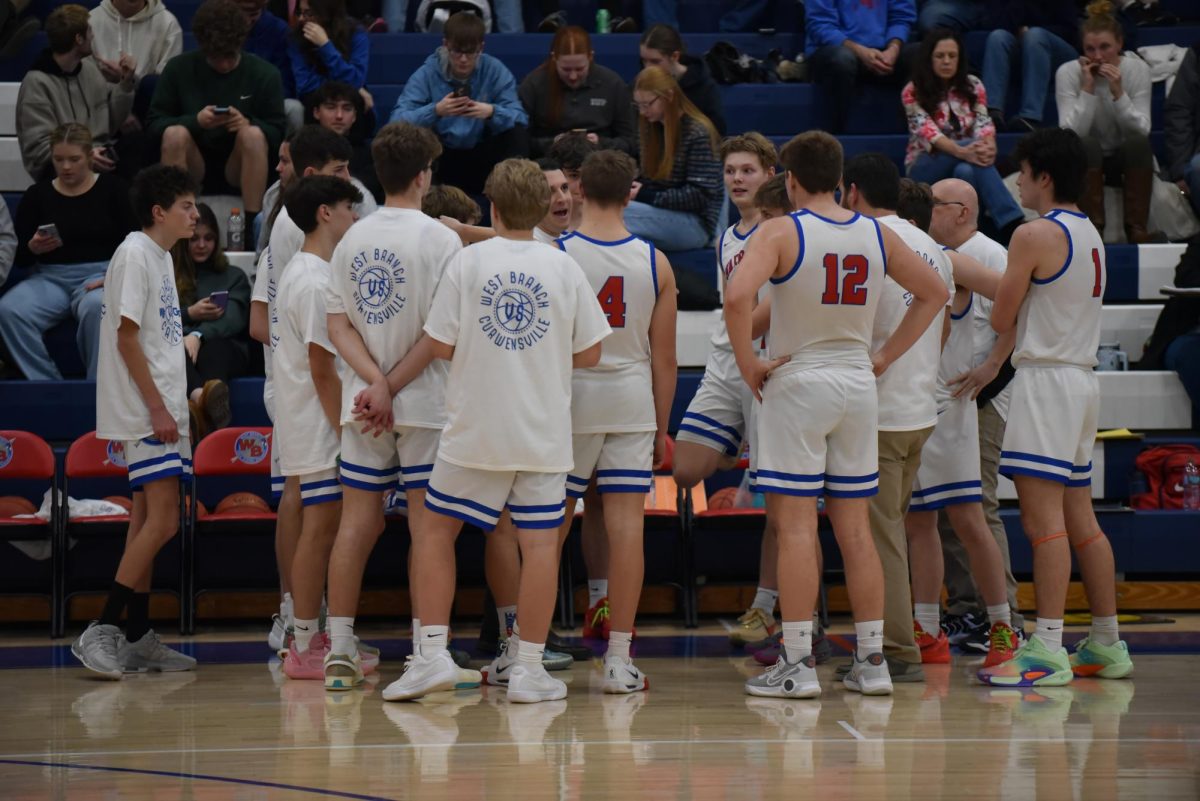 The team huddles and talks during a timeout against Curwensville. 
