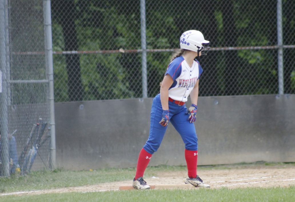 Mackenzie MacTavish stands on first base after hitting a single, waiting for the pitcher to deliver the next pitch.