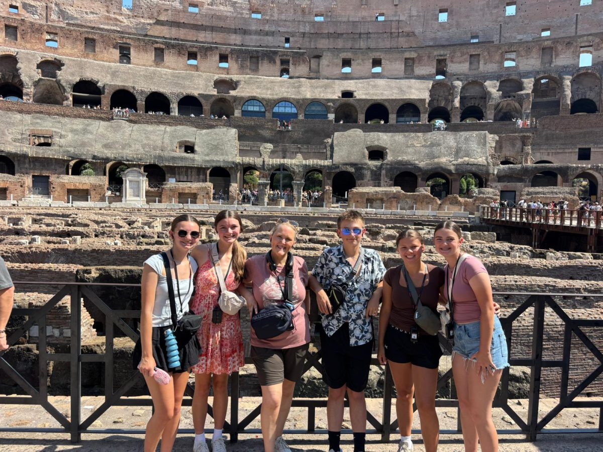 Spanish teacher Lori Bollinger poses with students at the Colosseum in Rome, Italy. 