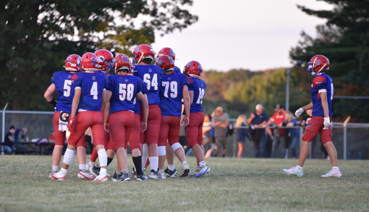 The Warrior offense huddles together to receive the play from quarterback Conner Danko.