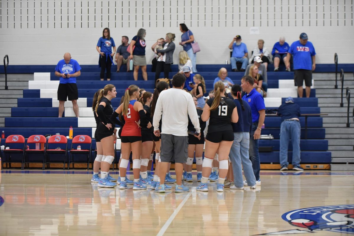 The Warrior volleyball team gathers after a great first set against their opponent. 