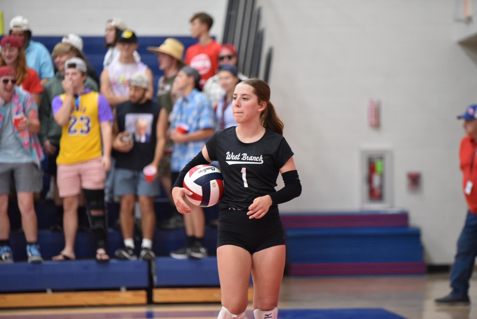 Kyla Kephart gets ready to serve while the student section cheers behind.