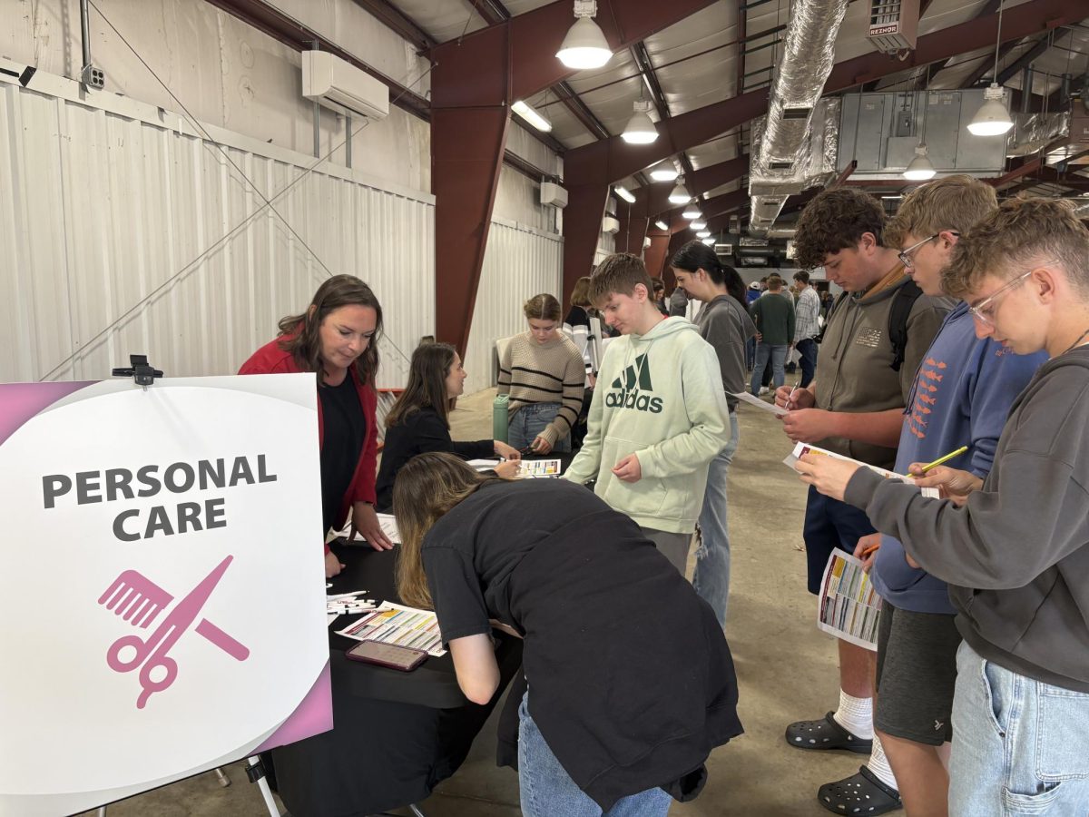 A group of seniors explores their options at the personal care table. 
