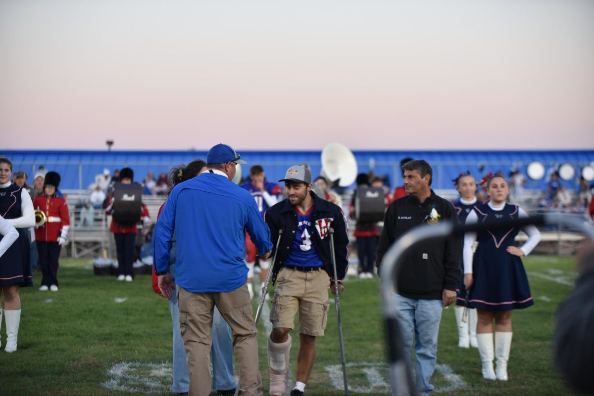 Coach McDowell shakes hands with injured player Gavin Dunlap on Senior Night.