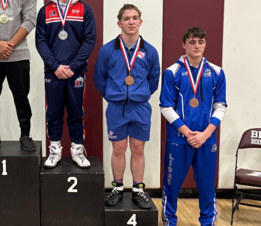 Jaykob Sample stands on the podium after placing fourth at the district tournament.