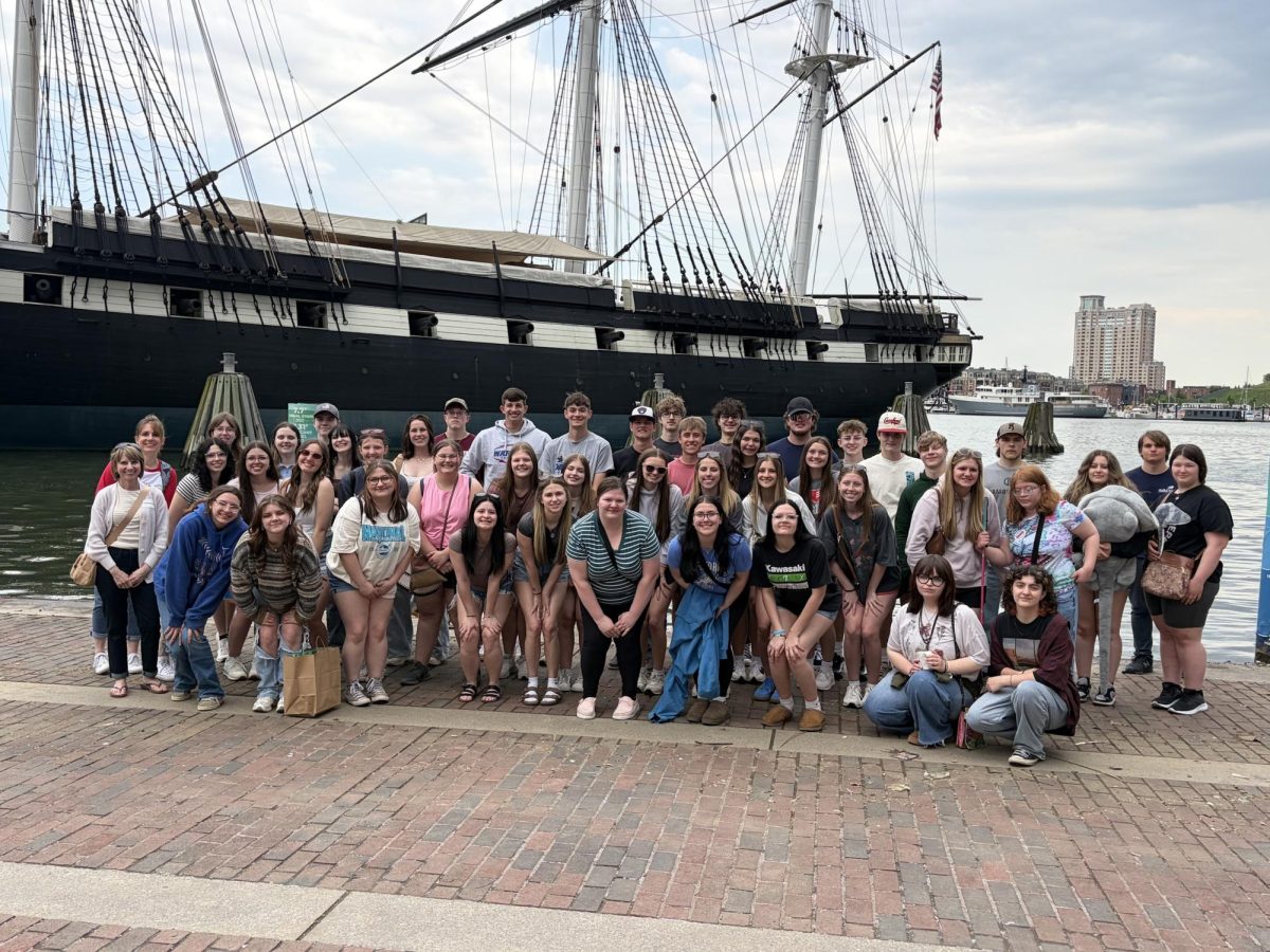 The senior class pictured in front of the USS Constellation, a historic Civil War-era vessel.