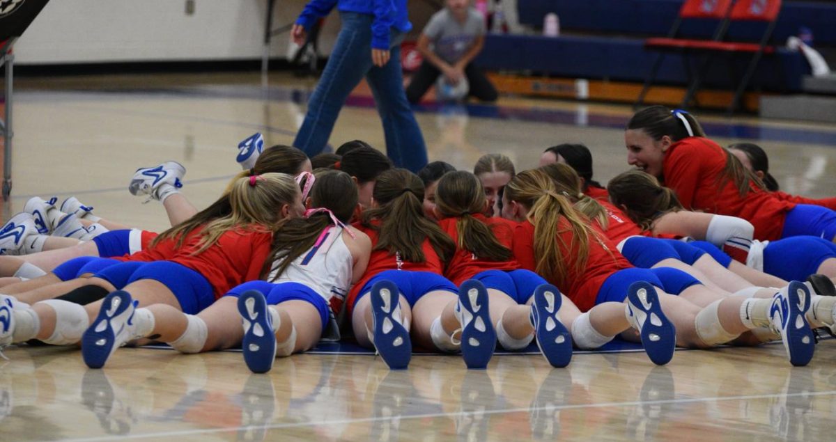 The Warrior volleyball team huddles before their pregame warm-up.